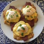 Eggs Benedict with homemade hollandaise sauce, bacon, and cheddar cauliflower hash browns